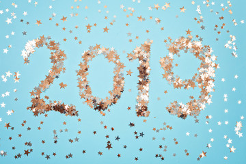 Creative photo of champagne bottle with confetti on blue background