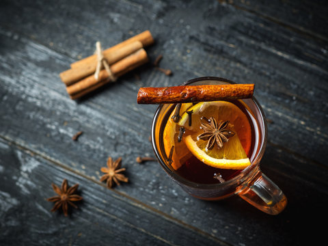 Hot mulled wine on a dark wooden table close-up