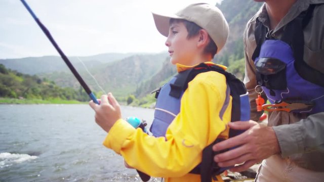 Happy Caucasian boy learning fishing with father on Colorado River on holiday