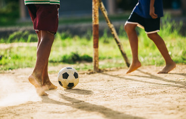 An action picture of a group of kid playing soccer football for exercise in community rural area...