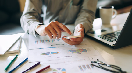 businessman working on project for analyzing company financial report balance statement with documents graphics at modern office space. Concept picture of business,economy, market,money and tax.