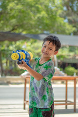Asian boy holding a water gun play Songkran festival in Thailand.