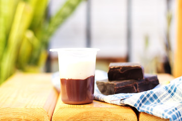 Sweet Homemade Chocolate Parfait Dessert with Whipped Cream on wood table in garden outside