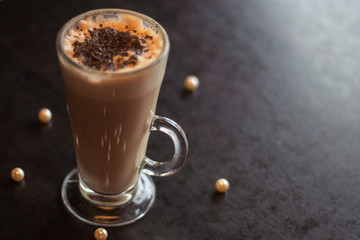 Morning cafe. A cup of coffee on the table with scattered pearls.