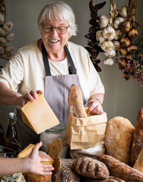Mature woman selling cheese at a deli