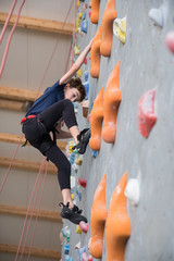 little boy climbing a rock wall
