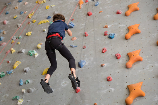 little boy climbing a rock wall
