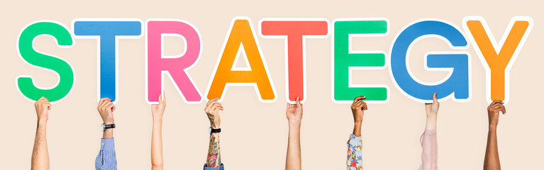 Hands holding up colorful letters forming the word strategy
