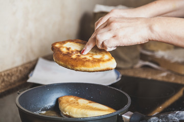 Women hands being removed from pan fried patty