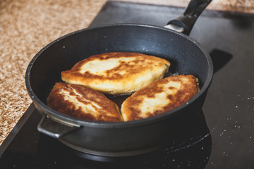 Three patties fried in pan
