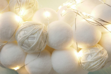 white pompons and shining garland background. Winter wool warm background.Winter season