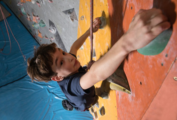 little boy climbing a rock wall

