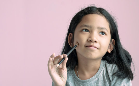 Little Girl Holding A Pencil And Thinking Something