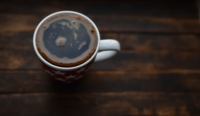 black coffee in white Cup on brown background
