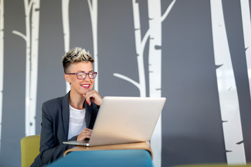 Portrait of successful businesswoman working with laptop