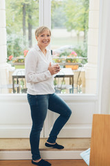 Attractive smiling housewife enjoying coffee