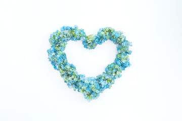 Love symbol made of hydrangea flowers on white background. Flat lay, top view. Valentines day symbol