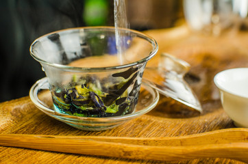 Organic blue tea Anchan in a teapot and a cups on wooden background