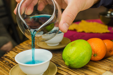 Organic blue tea Anchan in a teapot and a cups on wooden background