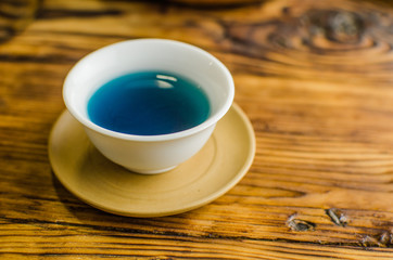 Organic blue tea Anchan in a teapot and a cups on wooden background