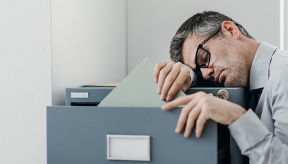 Tired office worker sleeping in the office - obrazy, fototapety, plakaty