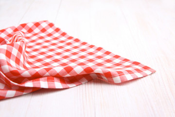 Red picnic cloth on wooden background.