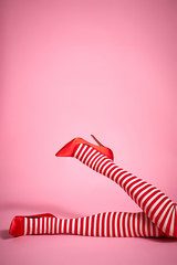 sexy santa woman's legs on a light pink background