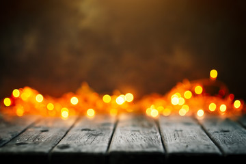 Merry Christmas and happy New year. Wooden table on Christmas lights background. Bokeh. Selective focus. Background with copy space.