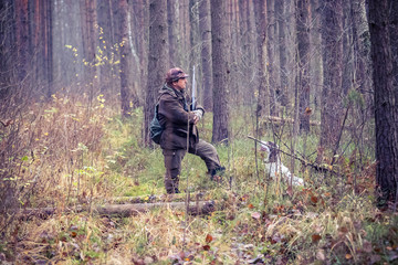 male hunter, in the forest, with arms, dog Springer Spaniel, hunting, autumn
