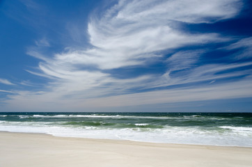 Fototapeta na wymiar Landscape with a white sand beach and with a dark blue and white sky