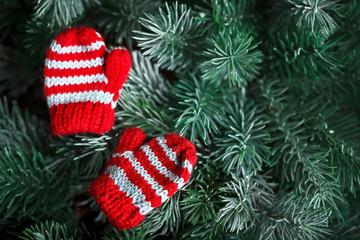 Merry Christmas and happy New year. Small knitted mittens on the Christmas tree. Background with copy space.