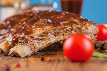 Delicious barbecued ribs seasoned with a spicy basting sauce and served with chopped fresh...