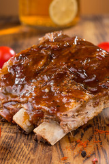 Delicious barbecued ribs seasoned with a spicy basting sauce and served with chopped fresh...