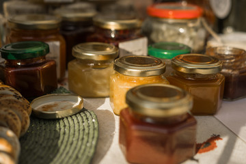 Small jars of honey. Many different varieties at the fair. Sunny summer day