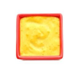 Tasty yellow sauce in bowl on white background