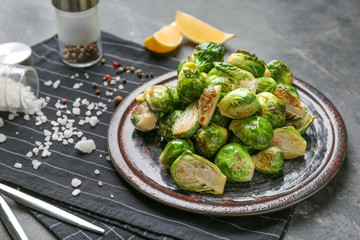 Plate with delicious roasted Brussels sprouts on table