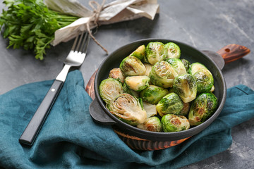 Pan with delicious roasted Brussels sprouts on table