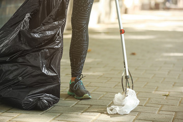 Woman gathering trash on city street © Pixel-Shot