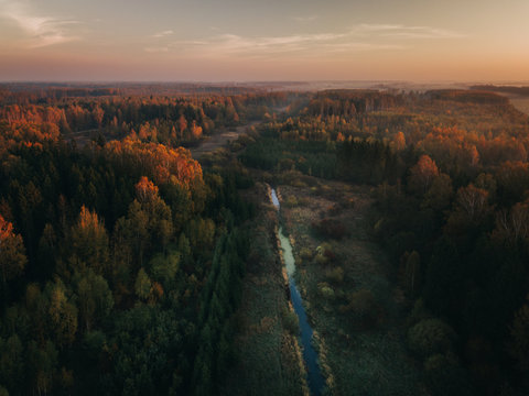 Foggy sunrise over river surrounded by agriculture fields and woods. Early autumn in Joniskis, Lithuania.