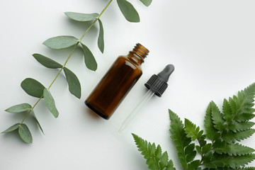 Bottle of eucalyptus essential oil on white background