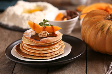 Hot tasty pancakes with pumpkin piece and chocolate sauce on plate