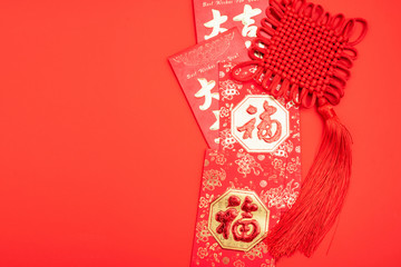 Ruyi knot and blessing red envelope on red background
