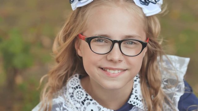 Portrait of a smiling 13 year old girl with glasses. Face close up.