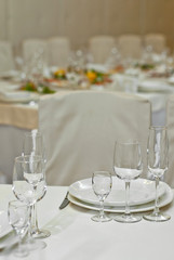 Glass dishes on a table on a white tablecloth. clean and empty. lovely, chic restaurant. cozy atmosphere. serving a banquet
