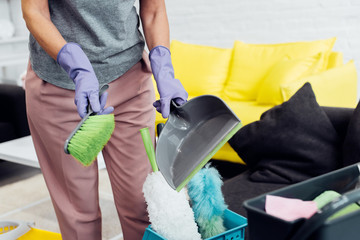 close up of woman in gloves with household supplies