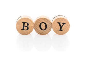 Word Boy from circular wooden tiles with letters children toy.