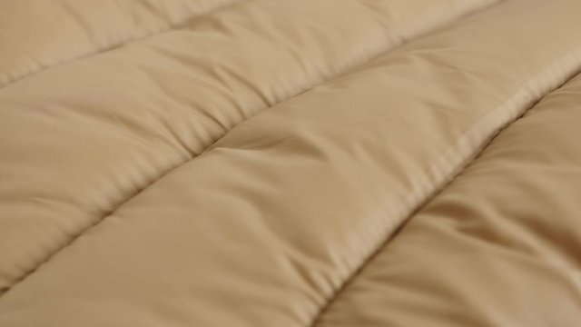 Ribs of quilted jacket close-up 4K tilting footage