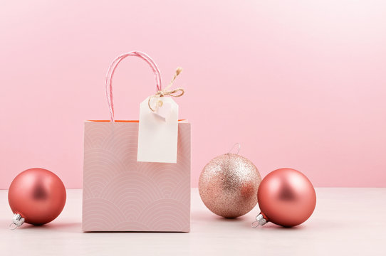Creative image of pink gift bag with empty tag, heart and christmas decoration. Christmas shopping, sales, presents concept