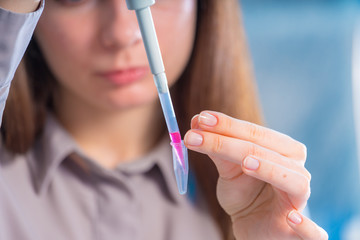 female technician with pipette in lad for DNA forensic testing