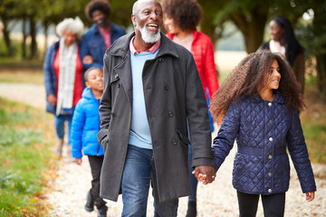 Multi Generation Family On Autumn Walk In Countryside Together